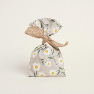 Υφασμάτινο πουγκί σε μπεζ απόχρωση με μοτίβο λευκών μαργαριτών και πράσινα φύλλα, δεμένο με σχοινί λινάτσας.