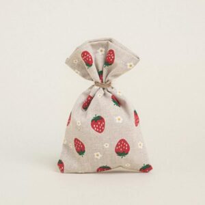 Υφασμάτινο πουγκί σε μπεζ χρώμα με μοτίβο φράουλες και λουλουδάκια.